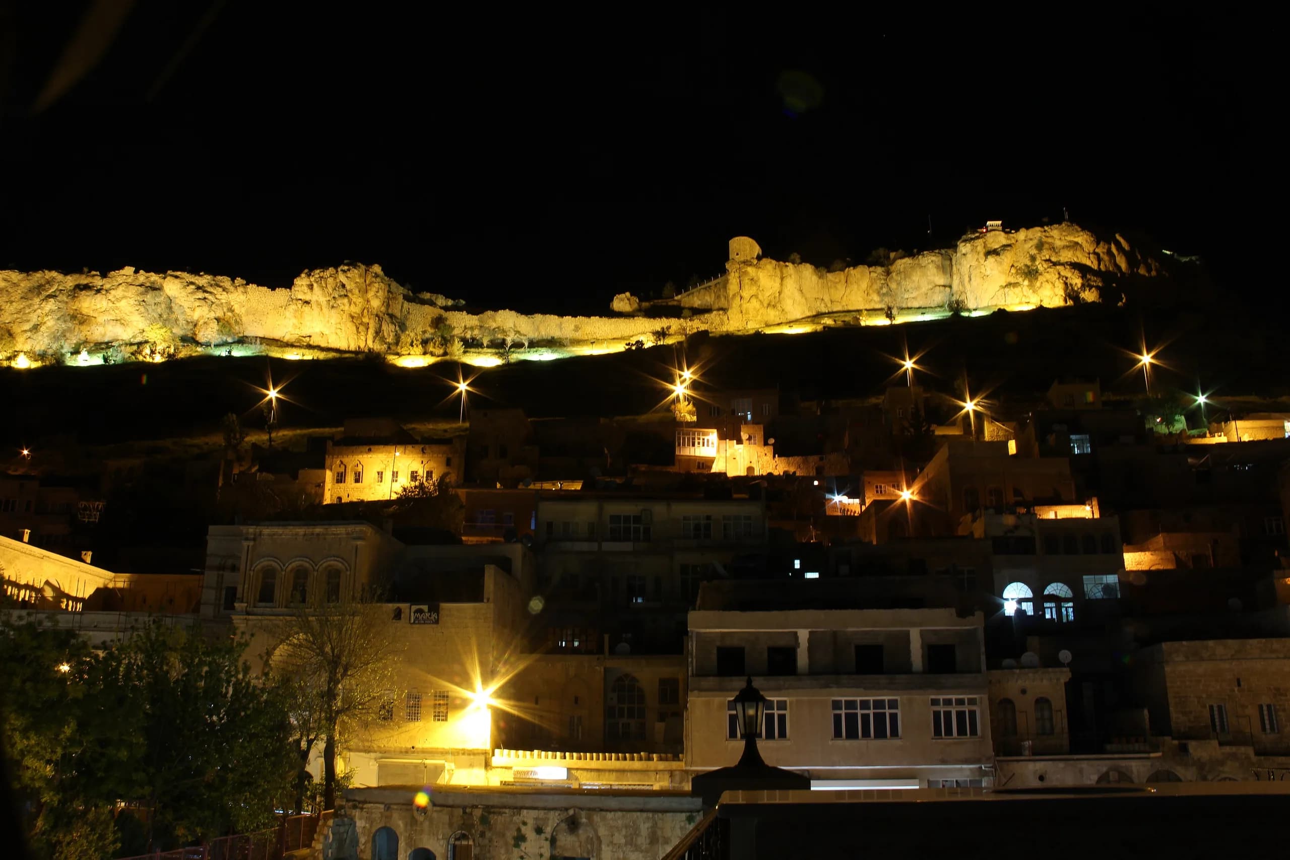 Gece aydınlanan Mardin kalesi ve taş evler. Fotoğraf: Hamdigumus, CC0